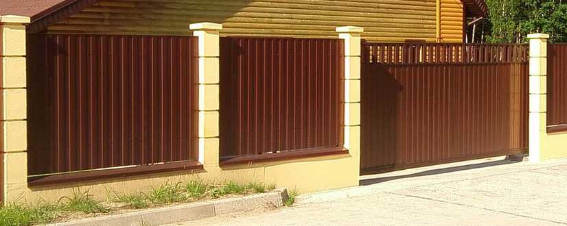 Коричневый забор из профлиста с откатными воротами